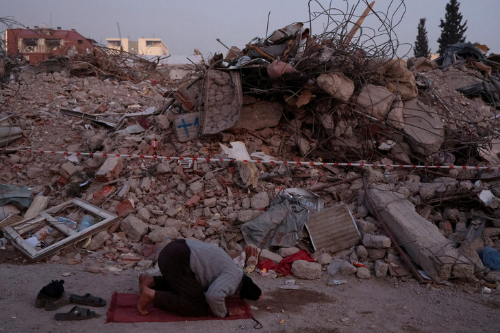 Một người đàn ông cầu nguyện gần đống đổ nát của những ngôi nhà bị phá hủy sau trận động đất chết người ở Kahramanmaras, Thổ Nhĩ Kỳ, ngày 14/2. Ảnh: Reuters
